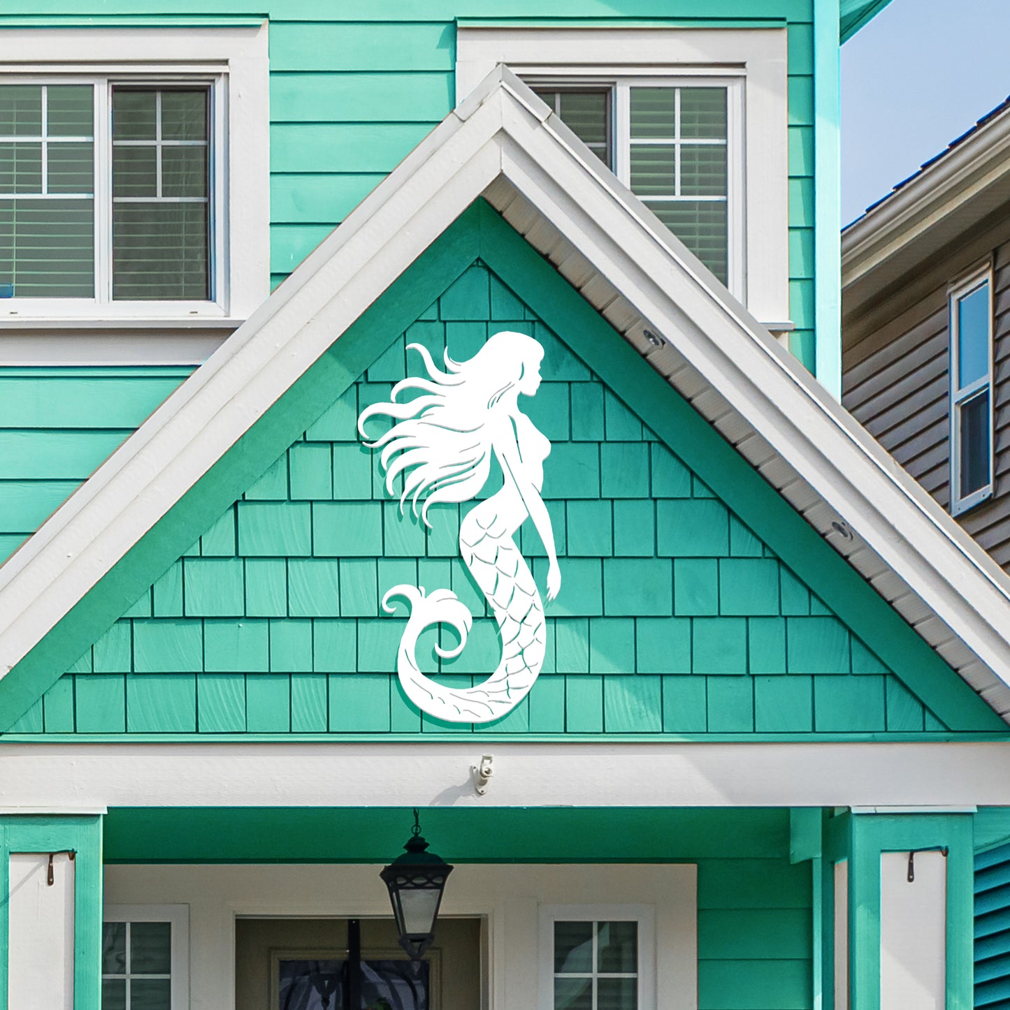 Close-up of Mermaid PVC Sign showing detailed scales and ocean-themed engraving, mounted on a coastal home wall.